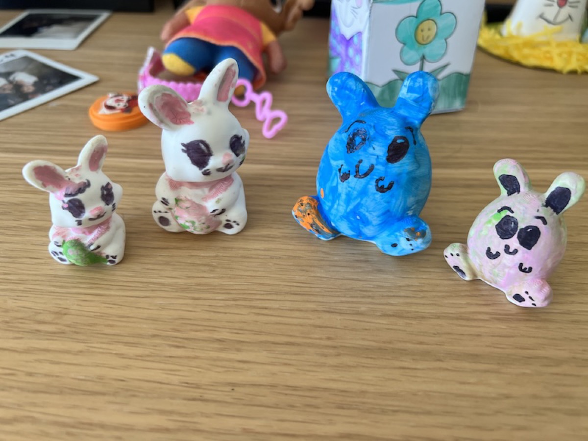 Copies of the two broken bunnies, 3D printed in matte white PLA at two different scales, and repainted by the kids